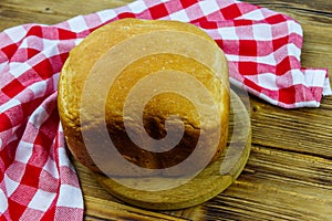 Homemade loaf of bread on wooden table freshly baked in an electric bread maker. Homemade baking