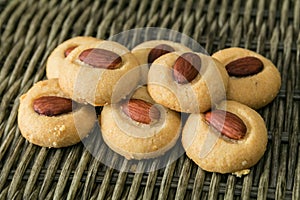 Homemade Macaroons with almond nuts closeup stacked on the wicker background