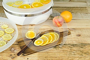 Homemade machine to dehydrate food with orange slices on kitchen table