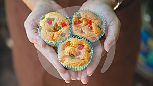 A homemade Mamon fruit cake in a woman hands in a brown apron photo