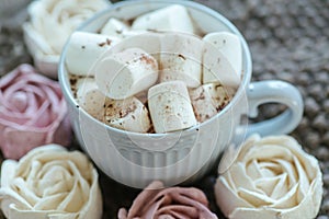 Homemade marshmallows around grey cup with cocoa or hot chocolate over the top