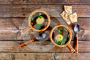 Homemade matzo ball soup in two pots with spoons photo