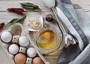 Homemade mayonnaise making concept.Organic healthy ingredients for making mayonnaise on a wooden light background