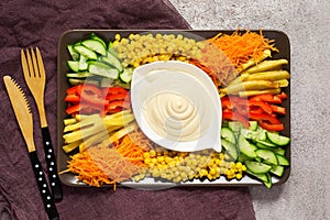 Homemade mayonnaise sauce. Dish with set of colorful vegetables.