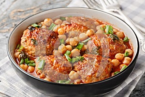 Homemade meatballs served with chickpeas, tomato and green onions close-up in a bowl. Horizontal