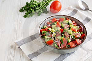 Homemade Mediterranean Cucumber Tomato Salad in a Bowl, side view. Space for text