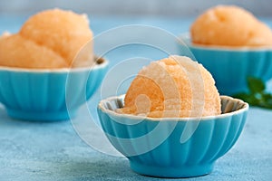 Homemade melon, apricot or peach ice cream , sorbet in bowl with mint leaves. Closeup
