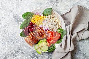 Homemade Mexican chicken burrito bowl with rice, beans, corn, tomato, avocado, spinach. Taco salad lunch bowl.