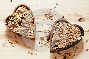 Homemade muesli in a bowl in the shape of a heart on a wooden ta