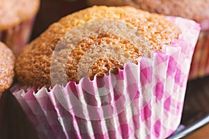 Homemade muffin in white pink paper cup close up