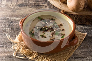 Homemade mushroom soup in bowl on wood