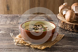 Homemade mushroom soup in bowl on wood