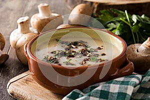 Homemade mushroom soup in bowl on wood