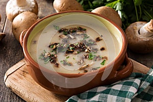 Homemade mushroom soup in bowl on wood