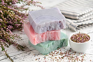 Homemade natural soap bars and heather flowers on table. Bars of organic soap