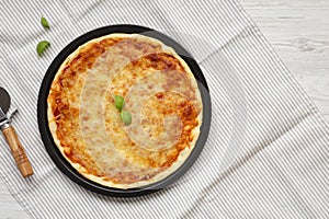 Homemade Neopolitan Pizza with Cheese and Basil, top view. Flat lay, from above, overhead. Copy space