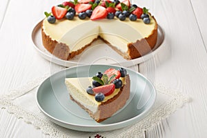 Homemade New York cheesecake slice decorated with fresh berries closeup on the plate. Horizontal