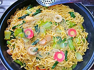 Homemade noodles have vegetables and sausage topping