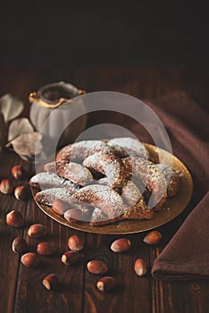 Homemade nuts cookies chocolate crescent with sugar powder on brown wooden background. Copy space. Soft focus