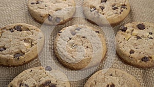 Homemade oatmeal cookies with chocolate, raisins and nuts, stacked on a rustic burlap