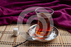 A cup of tea with sugar on wooden background
