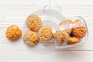 Homemade oatmeal cookies on white wooden table with milk on background