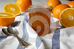 Homemade orange marmelade in glass jar, side view. Close-up
