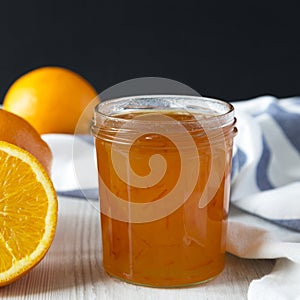 Homemade orange marmelade in glass jar, side view. Close-up