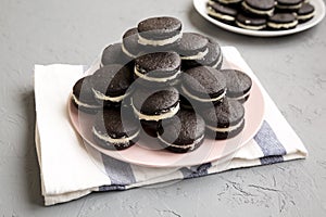 Homemade Oreos on a pink plate on a gray background, low angle view