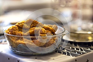 Homemade organic crispy fried fish in batter in a glass bowl on the table. Baked natural pieces of carp