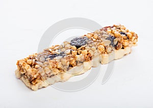 Homemade organic granola cereal bar with nuts and dried fruit on white background