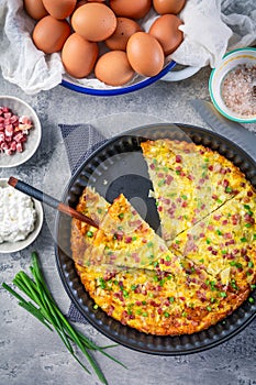 Homemade oven baked frittata with curd cheese, bacon, onion and chives