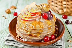 Homemade pancakes with honey, apple, cranberries and nuts