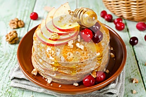 Homemade pancakes with honey, apple, cranberries and nuts