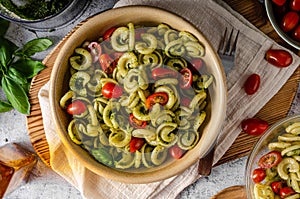 Homemade pasta with fresh basil pesto and tomatoes