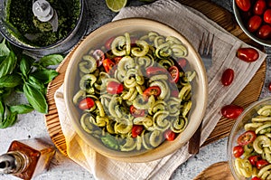 Homemade pasta with fresh basil pesto and tomatoes