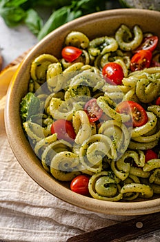 Homemade pasta with fresh basil pesto and tomatoes