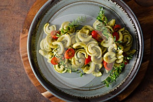 Homemade pasta with fresh basil pesto and tomatoes