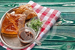 Homemade pastries on a metallic dish with sauce and rosemary