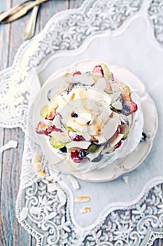 Homemade Pavlova with Fresh Fruits and Coconut; Cake with blueberries, strawberries, grapes, raspberries and coconut