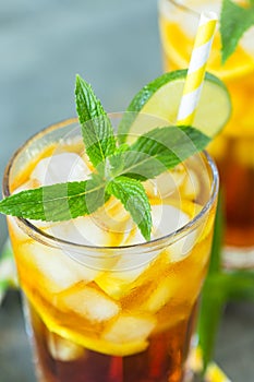 Homemade peach ice tea with ice, lime and mint in the glass