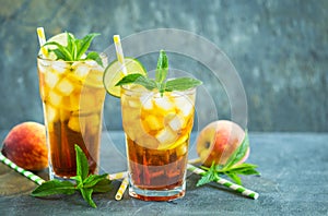 Homemade peach ice tea with ice, lime and mint in the glass