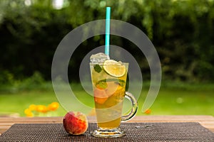 Homemade peach ice tea with lime and lemon balm