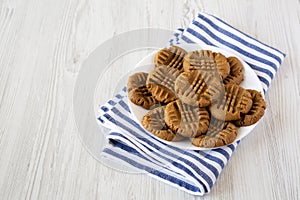 Homemade Peanut Butter Cookies on a plate on a white wooden background, side view. Space for text