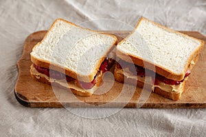 Homemade Peanut Butter and Jelly Sandwich on a rustic wooden board, side view