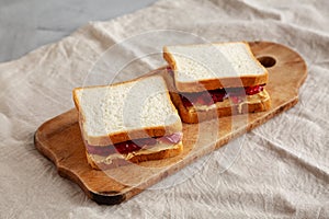 Homemade Peanut Butter and Jelly Sandwich on a rustic wooden board, side view