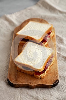 Homemade Peanut Butter and Jelly Sandwich on a rustic wooden board, side view