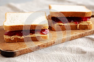 Homemade Peanut Butter and Jelly Sandwich on a rustic wooden board, side view