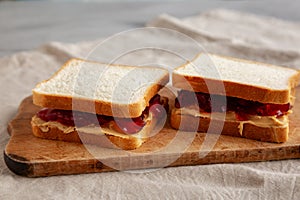 Homemade Peanut Butter and Jelly Sandwich on a rustic wooden board, side view