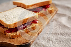 Homemade Peanut Butter and Jelly Sandwich on a rustic wooden board, side view